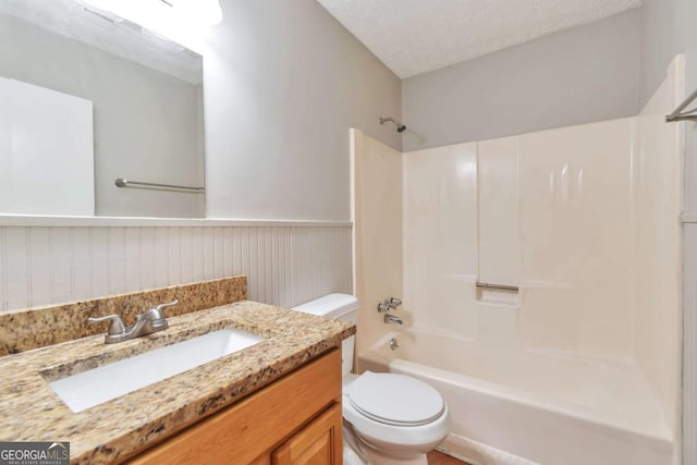 744 Martin Rd, Stone Mountain, GA 30088 - full bath featuring vanity, shower / tub combination, a wainscoted wall, and a textured ceiling