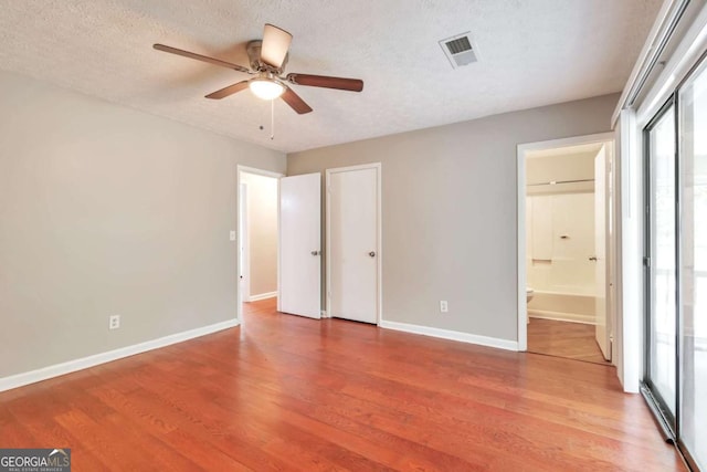 744 Martin Rd, Stone Mountain, GA 30088 - unfurnished bedroom featuring wood finished floors, a textured ceiling, ensuite bathroom, and a ceiling fan