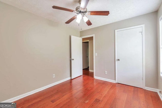 744 Martin Rd, Stone Mountain, GA 30088 - unfurnished bedroom with wood finished floors, a ceiling fan, and a textured ceiling