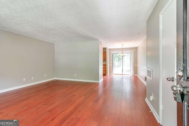 744 Martin Rd, Stone Mountain, GA 30088 - unfurnished living room with a chandelier, a textured ceiling, and hardwood / wood-style flooring