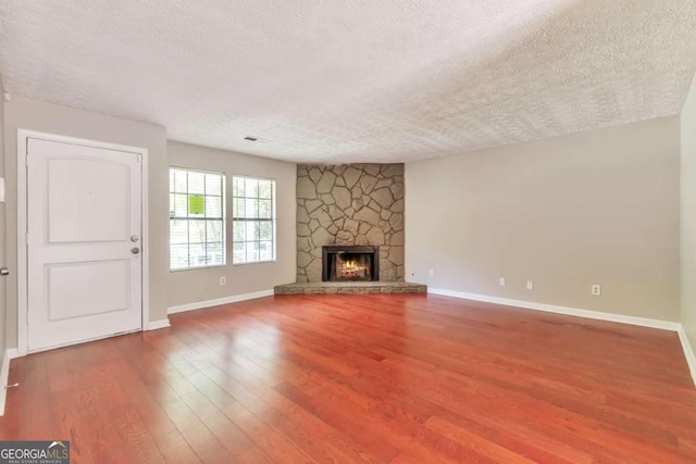 744 Martin Rd, Stone Mountain, GA 30088 - unfurnished living room featuring a textured ceiling, wood finished floors, and a fireplace