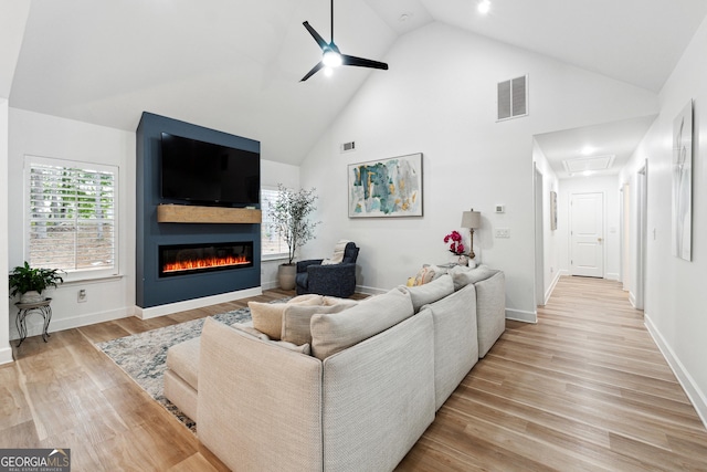 6565 Nix Rd, Dawsonville, GA 30534 - living room featuring a ceiling fan, a large fireplace, light wood-style flooring, high vaulted ceiling, and baseboards