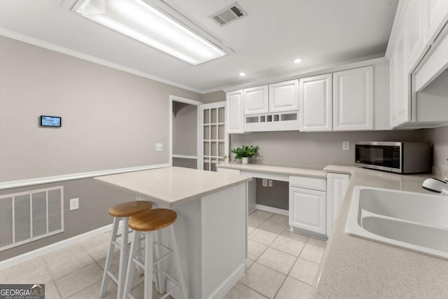 4223 N Mountain Rd NE, Marietta, GA 30066 - kitchen featuring stainless steel microwave, a sink, light tile patterned floors, white cabinetry, and ornamental molding