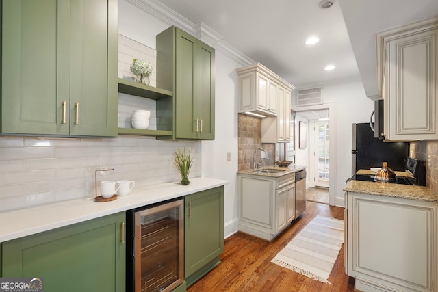 653 N Highland Ave NE Unit 5, Atlanta, GA 30306 - kitchen with wine cooler, green cabinets, backsplash, stainless steel appliances, and crown molding