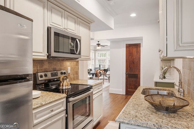 653 N Highland Ave NE Unit 5, Atlanta, GA 30306 - kitchen with stainless steel appliances, ceiling fan, tasteful backsplash, ornamental molding, and light stone countertops