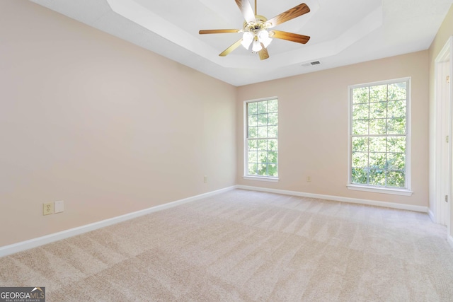 7186 Raintree Loop, Jonesboro, GA 30236 - empty room with a tray ceiling, baseboards, light colored carpet, and a ceiling fan