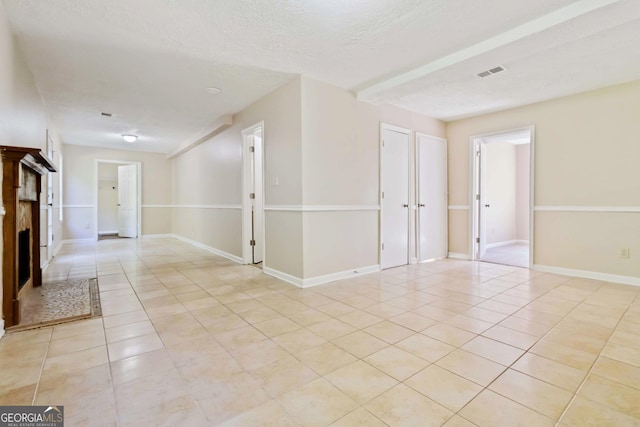7186 Raintree Loop, Jonesboro, GA 30236 - spare room with light tile patterned floors, a textured ceiling, a fireplace, and baseboards