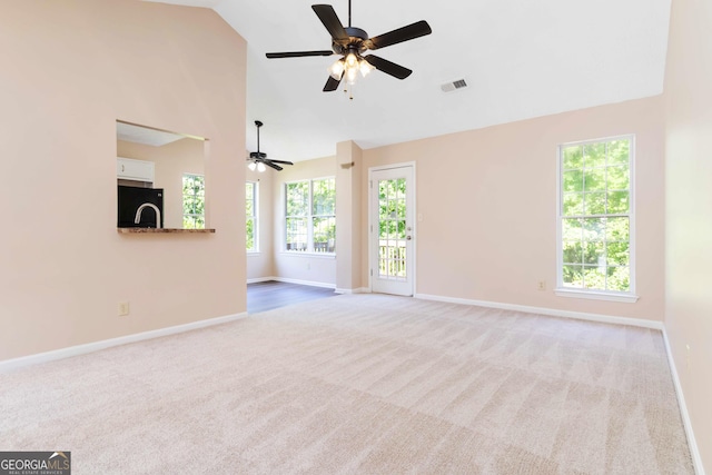 7186 Raintree Loop, Jonesboro, GA 30236 - unfurnished living room with carpet flooring, baseboards, plenty of natural light, a ceiling fan, and high vaulted ceiling