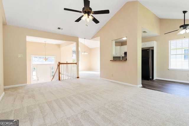 7186 Raintree Loop, Jonesboro, GA 30236 - unfurnished living room featuring ceiling fan, carpet floors, baseboards, high vaulted ceiling, and a chandelier