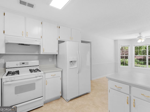 264 Keller Dr, Mcdonough, GA 30252 - kitchen with white appliances, under cabinet range hood, white cabinets, light countertops, and ceiling fan