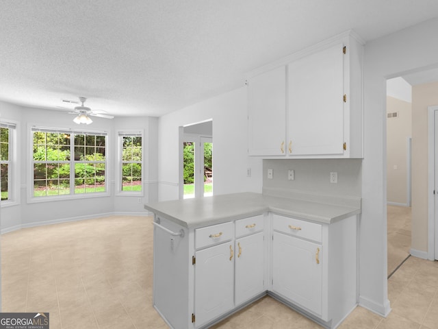 264 Keller Dr, Mcdonough, GA 30252 - kitchen featuring light countertops, ceiling fan, white cabinetry, a peninsula, and baseboards