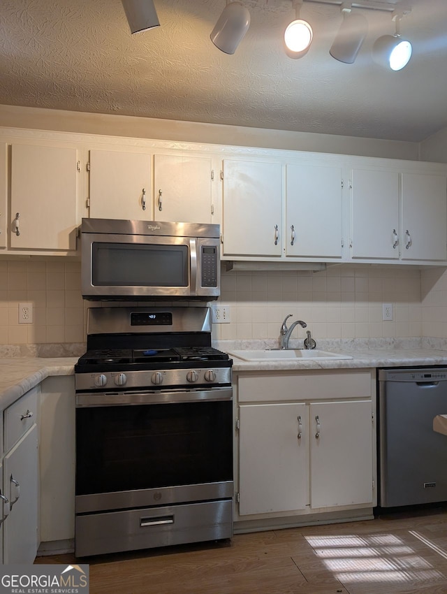 206 River Run, Atlanta, GA 30350 - kitchen featuring appliances with stainless steel finishes, a sink, backsplash, light countertops, and white cabinets