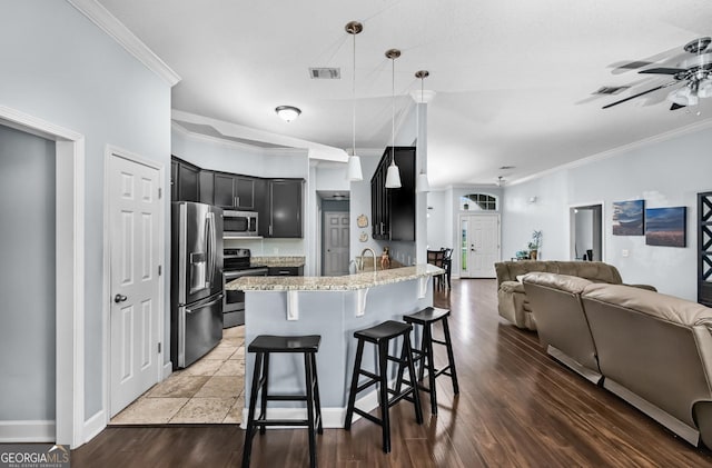 326 Daniel Trent Way, Kingsland, GA 31548 - kitchen featuring appliances with stainless steel finishes, open floor plan, dark cabinets, a ceiling fan, and crown molding