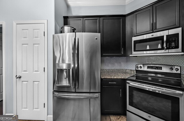 326 Daniel Trent Way, Kingsland, GA 31548 - kitchen with stainless steel appliances, dark cabinetry, backsplash, ornamental molding, and stone counters