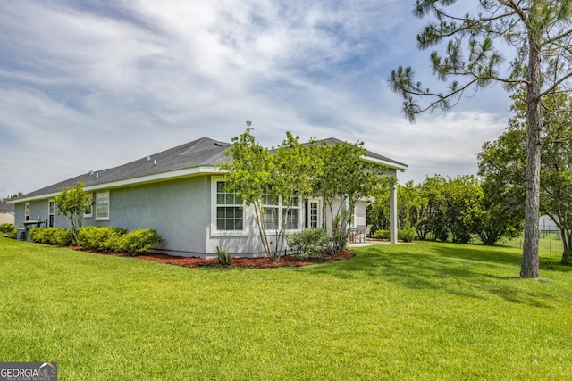 326 Daniel Trent Way, Kingsland, GA 31548 - view of home's exterior featuring stucco siding and a yard