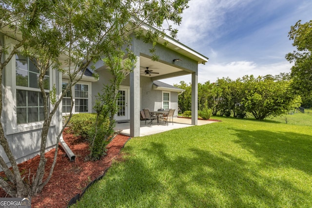 326 Daniel Trent Way, Kingsland, GA 31548 - back of house featuring stucco siding, a ceiling fan, a lawn, and a patio area