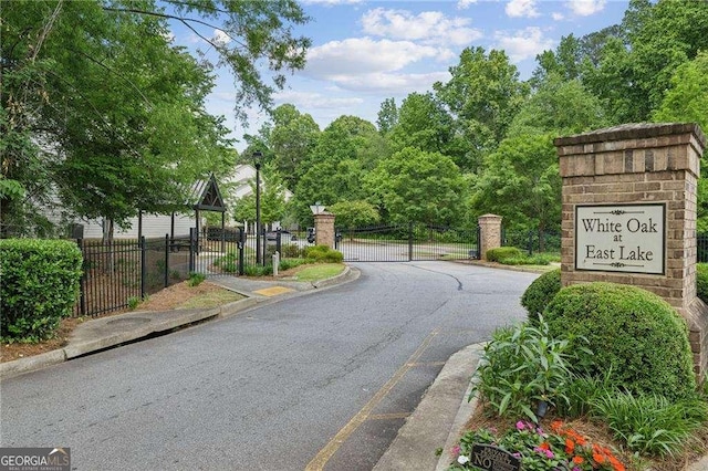 2817 White Oak Ln, Decatur, GA 30032 - view of asphalt street featuring a gate, curbs, a gated entry, and street lights