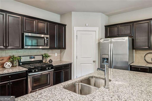 2817 White Oak Ln, Decatur, GA 30032 - kitchen with appliances with stainless steel finishes, a sink, tasteful backsplash, light stone counters, and dark brown cabinets