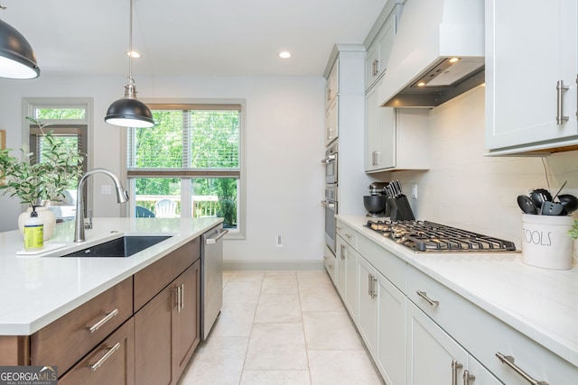 1013 Liberty Springs Dr, Woodstock, GA 30188 - kitchen featuring custom exhaust hood, appliances with stainless steel finishes, light countertops, decorative light fixtures, and white cabinetry