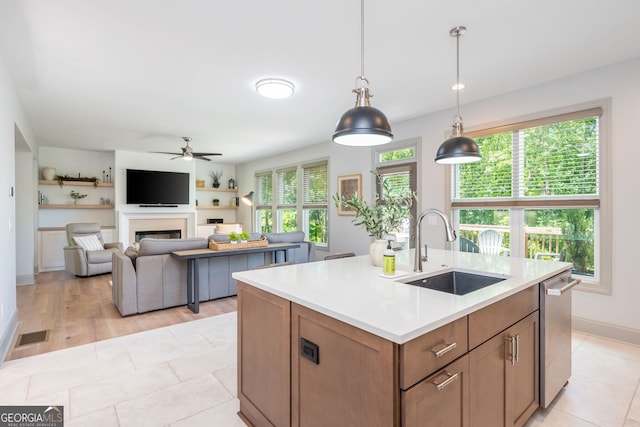 1013 Liberty Springs Dr, Woodstock, GA 30188 - kitchen with a ceiling fan, light countertops, a fireplace, dishwasher, and pendant lighting