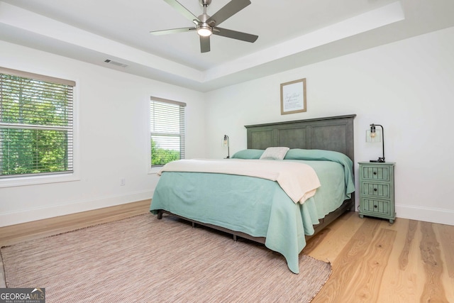 1013 Liberty Springs Dr, Woodstock, GA 30188 - bedroom with light wood-type flooring, a raised ceiling, and ceiling fan