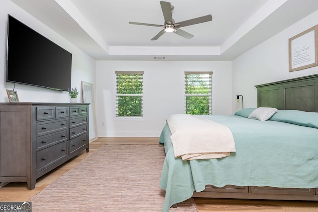 1013 Liberty Springs Dr, Woodstock, GA 30188 - bedroom featuring a raised ceiling, light wood-style floors, and a ceiling fan