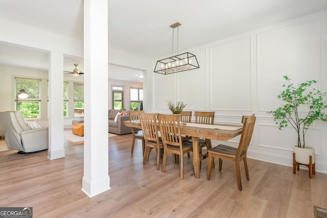 1013 Liberty Springs Dr, Woodstock, GA 30188 - dining room with a decorative wall, light wood-type flooring, a ceiling fan, and a chandelier
