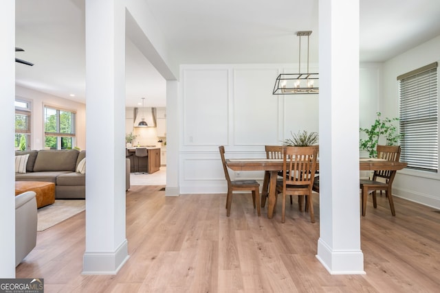 1013 Liberty Springs Dr, Woodstock, GA 30188 - dining area with light wood-style flooring, a chandelier, and a decorative wall