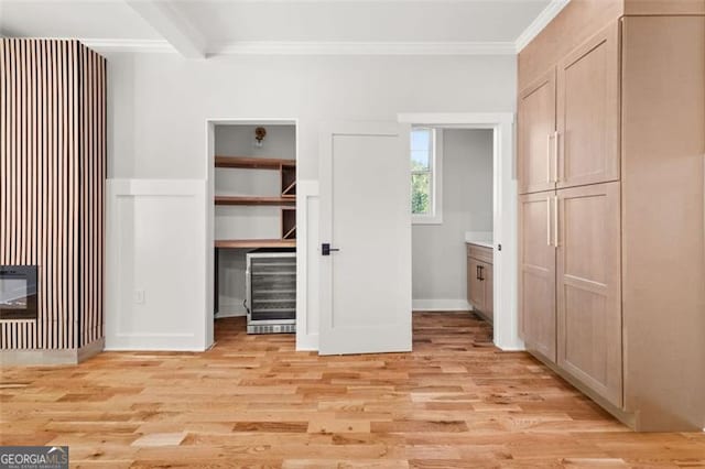327 Ohm, Avondale Estates, GA 30002 - unfurnished bedroom featuring wine cooler, crown molding, light wood-style flooring, a walk in closet, and baseboards