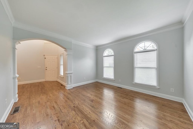 1575 Petal Pt NW, Kennesaw, GA 30152 - empty room featuring arched walkways, decorative columns, wood finished floors, baseboards, and ornamental molding