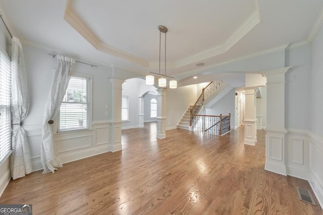 1575 Petal Pt NW, Kennesaw, GA 30152 - unfurnished dining area featuring a raised ceiling, a wainscoted wall, ornamental molding, light wood finished floors, and arched walkways