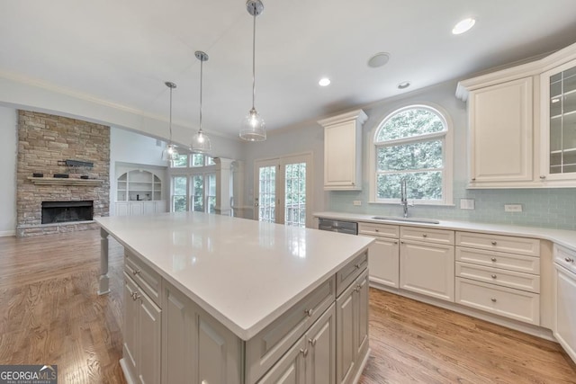 1575 Petal Pt NW, Kennesaw, GA 30152 - kitchen featuring a sink, stainless steel dishwasher, open floor plan, light countertops, and a stone fireplace
