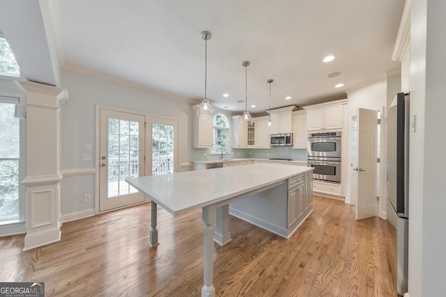 1575 Petal Pt NW, Kennesaw, GA 30152 - kitchen with appliances with stainless steel finishes, light countertops, ornamental molding, tasteful backsplash, and light wood-type flooring
