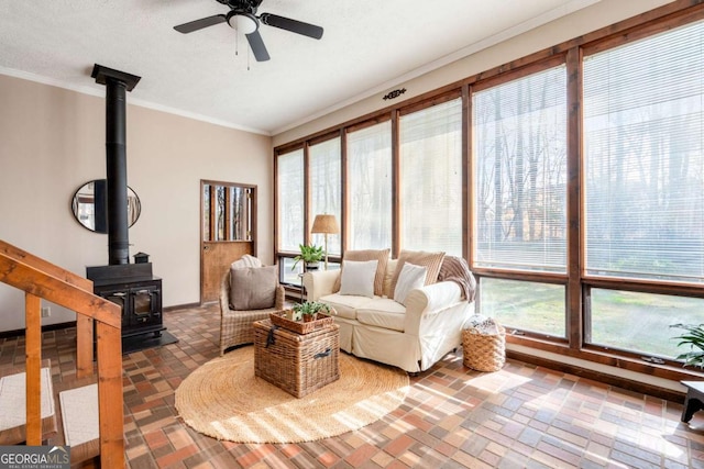2796 County Line Rd NW, Acworth, GA 30101 - living room with a wood stove, a ceiling fan, crown molding, brick patterned floors, and baseboards