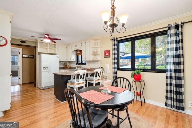 2796 County Line Rd NW, Acworth, GA 30101 - dining room with light wood-style flooring, a chandelier, ceiling fan, crown molding, and baseboards