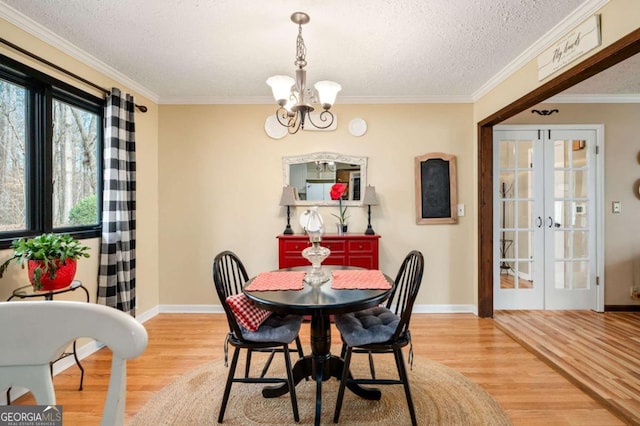 2796 County Line Rd NW, Acworth, GA 30101 - dining area featuring light wood-type flooring, a chandelier, baseboards, crown molding, and a textured ceiling