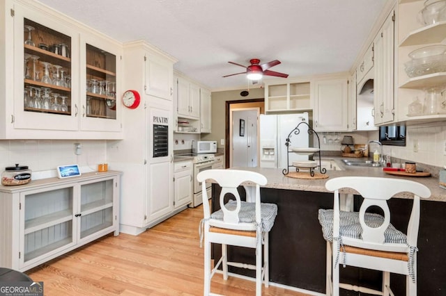 2796 County Line Rd NW, Acworth, GA 30101 - kitchen featuring white appliances, a sink, a peninsula, a ceiling fan, and light countertops