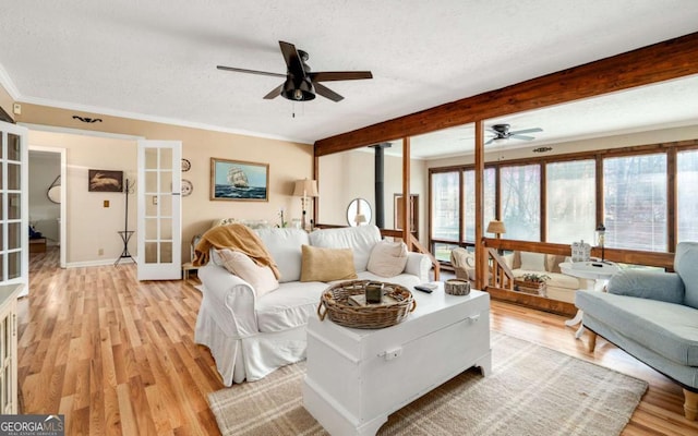 2796 County Line Rd NW, Acworth, GA 30101 - living room featuring french doors, ceiling fan, a textured ceiling, light wood-style flooring, and crown molding