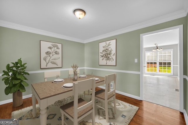 2151 Hamstead Ct, Suwanee, GA 30024 - dining area with wood finished floors, a chandelier, ornamental molding, and baseboards