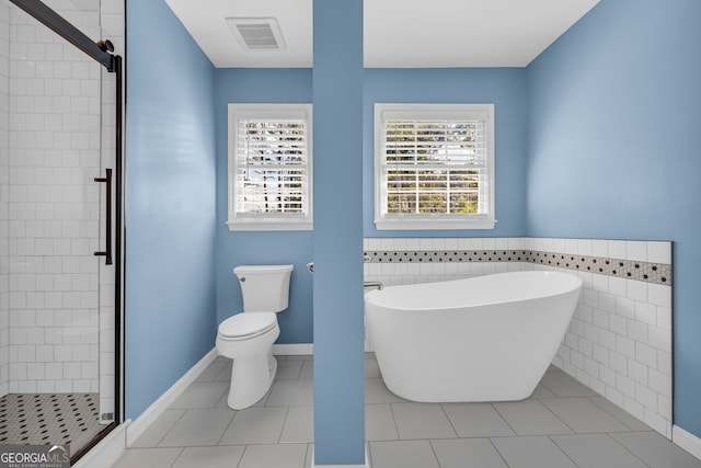 2151 Hamstead Ct, Suwanee, GA 30024 - bathroom featuring a soaking tub, a stall shower, toilet, a wainscoted wall, and tile patterned floors