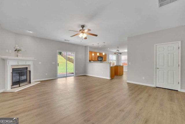 955 Mill Creek Ave, Canton, GA 30115 - unfurnished living room with ceiling fan, light wood-style floors, a glass covered fireplace, baseboards, and recessed lighting