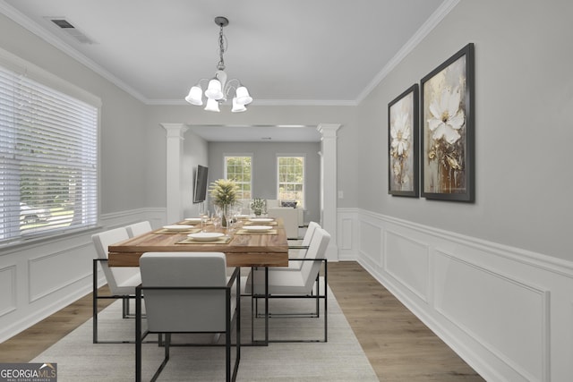 955 Mill Creek Ave, Canton, GA 30115 - dining space featuring decorative columns, wood finished floors, a chandelier, a wainscoted wall, and a decorative wall