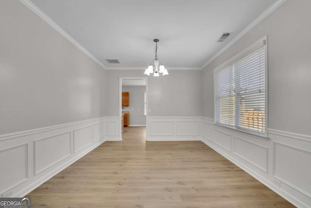 955 Mill Creek Ave, Canton, GA 30115 - unfurnished dining area featuring a chandelier, crown molding, a wainscoted wall, light wood-style floors, and a decorative wall