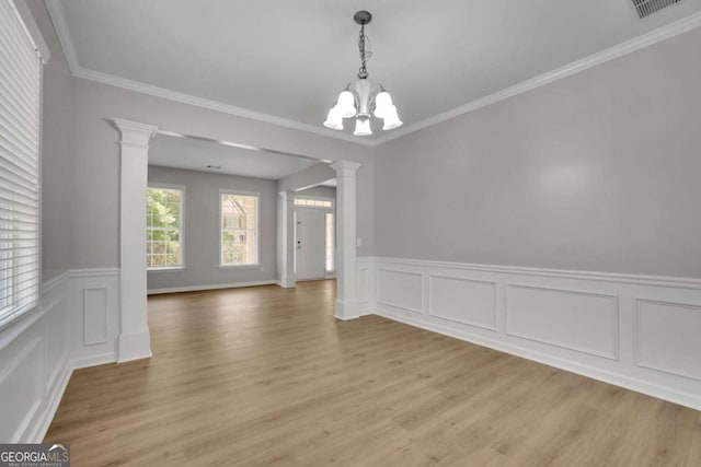 955 Mill Creek Ave, Canton, GA 30115 - unfurnished dining area with ornate columns, a chandelier, light wood-type flooring, wainscoting, and crown molding