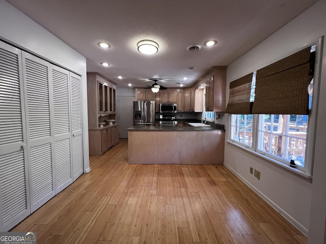 2976 Twin Pine Rd, Thomson, GA 30824 - kitchen with appliances with stainless steel finishes, a sink, dark countertops, a peninsula, and light wood-style flooring