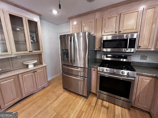 2976 Twin Pine Rd, Thomson, GA 30824 - kitchen with appliances with stainless steel finishes, light wood-style floors, a textured ceiling, and glass insert cabinets