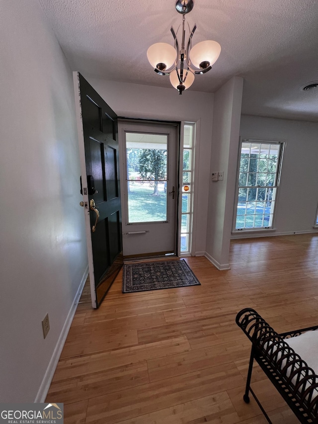 2976 Twin Pine Rd, Thomson, GA 30824 - foyer entrance featuring a textured ceiling, baseboards, a chandelier, and light wood-type flooring