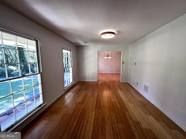 2976 Twin Pine Rd, Thomson, GA 30824 - spare room featuring a chandelier, wood finished floors, a textured ceiling, and baseboards