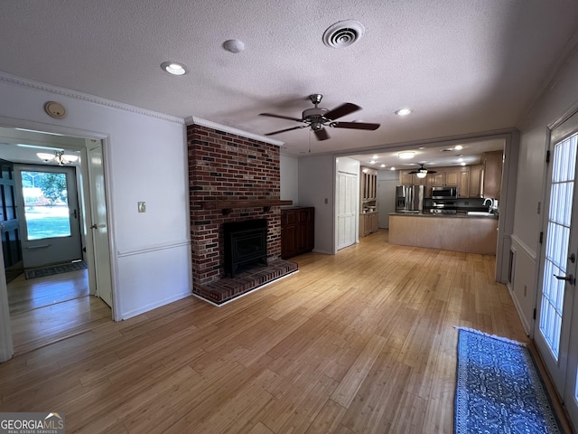2976 Twin Pine Rd, Thomson, GA 30824 - unfurnished living room with a textured ceiling, a ceiling fan, light wood-type flooring, a brick fireplace, and a sink