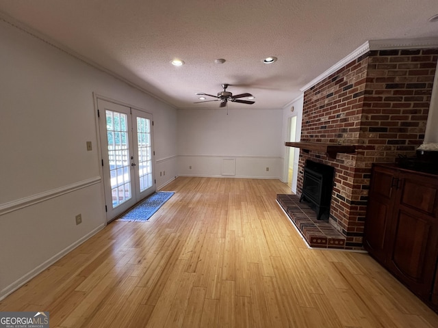 2976 Twin Pine Rd, Thomson, GA 30824 - unfurnished living room with a textured ceiling, ceiling fan, light wood-type flooring, french doors, and a fireplace